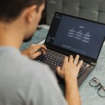 Tech reviewer using a laptop running AI content detection and writing software