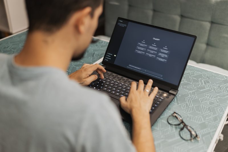 Tech reviewer using a laptop running AI content detection and writing software