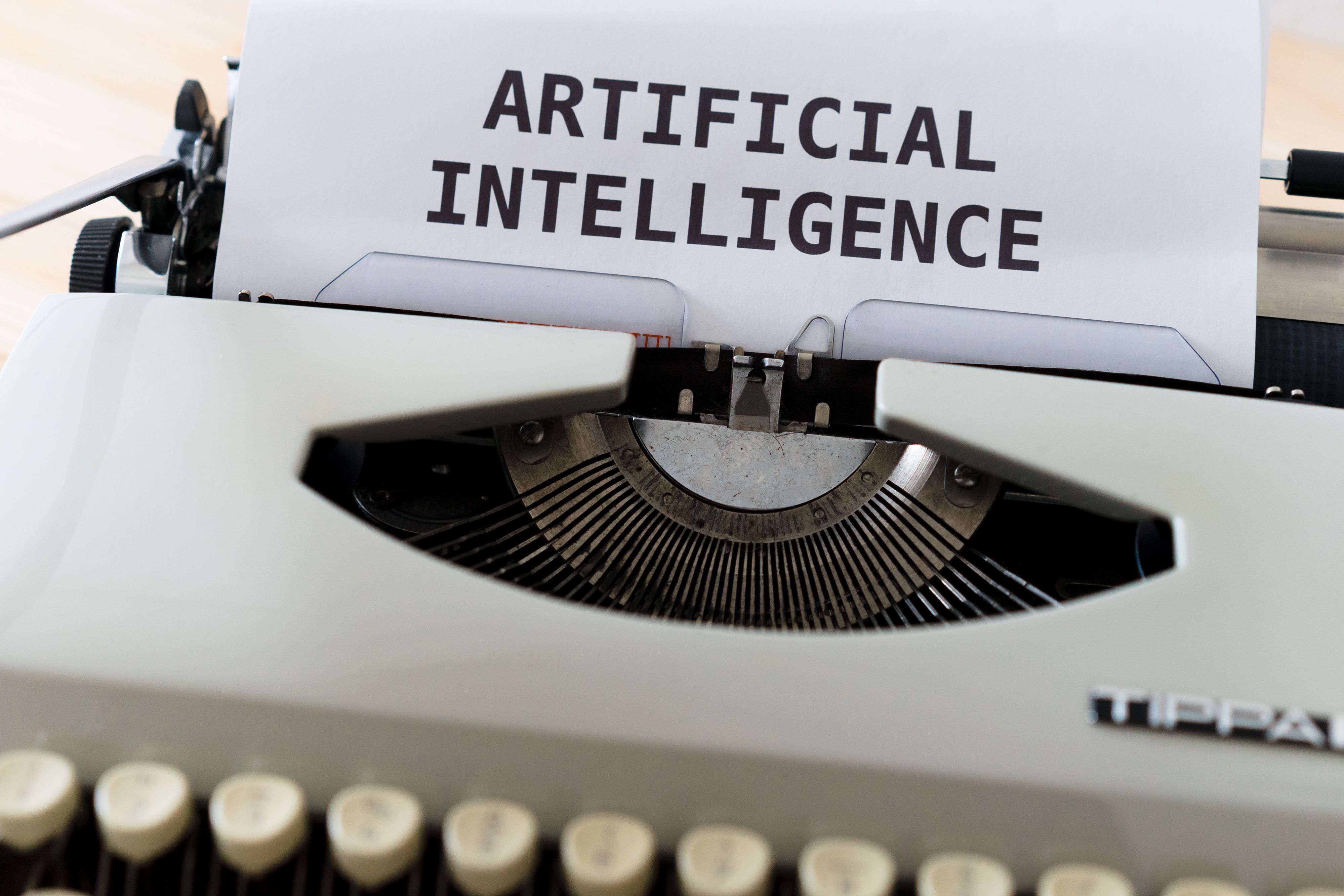 Typewriter printing the words artificial intelligence on paper